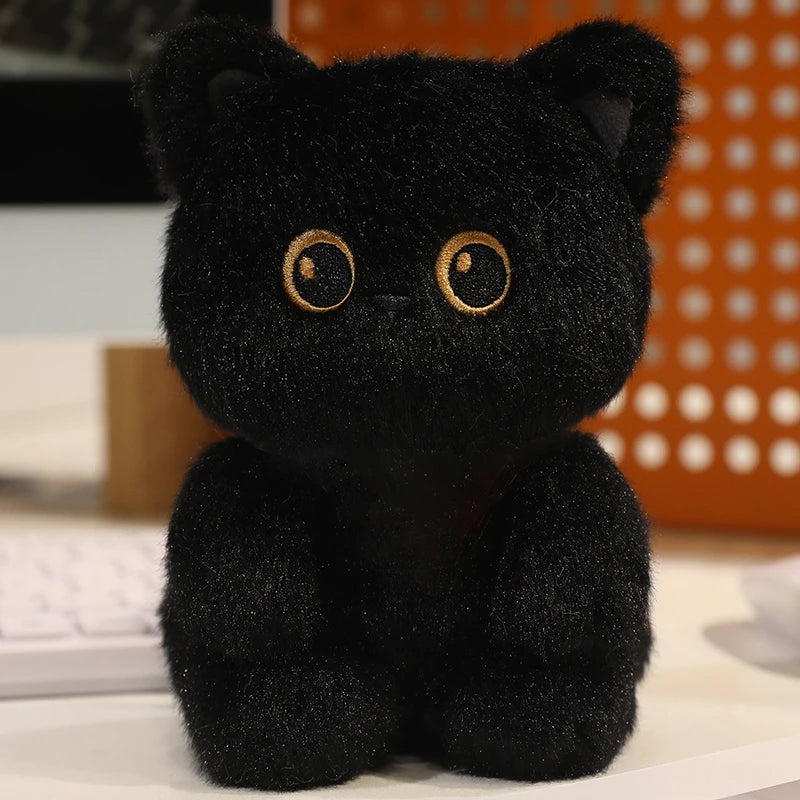 Black plush cat kawaii toy with yellow eyes on a blurred background