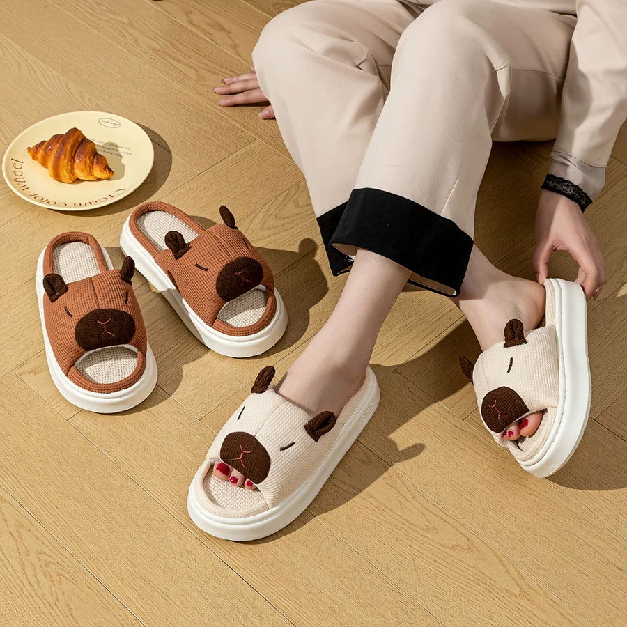 Person wearing kawaii cartoon dog slippers on a wooden floor with a plate of food in the background.