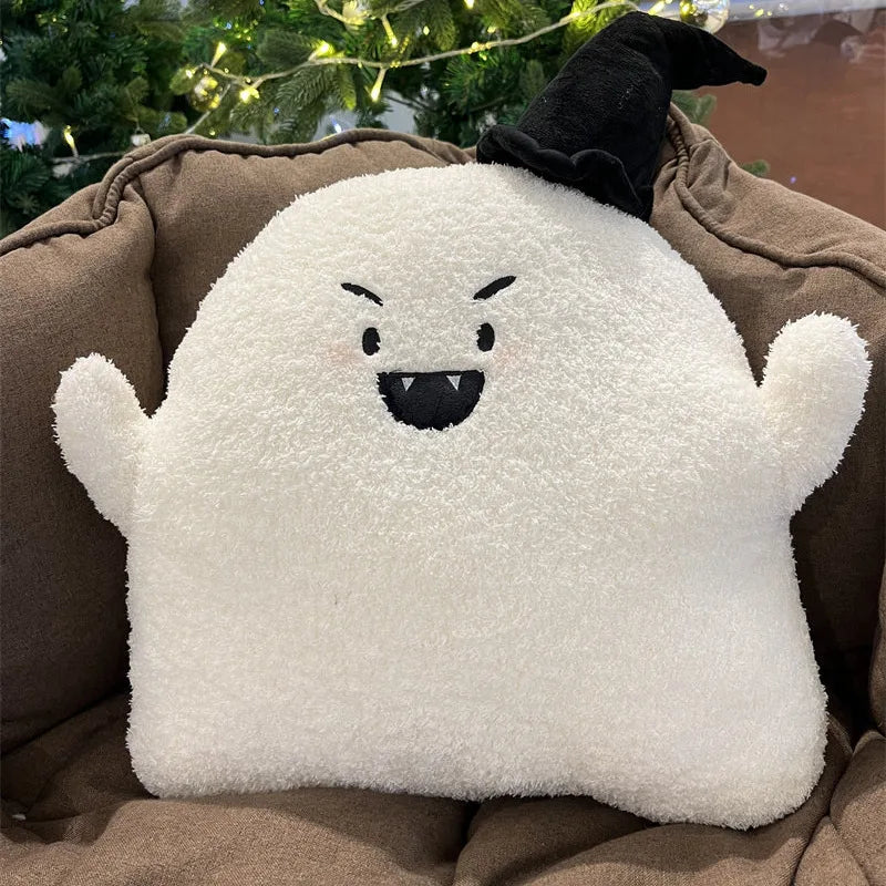 White kawaii plush ghost pillow with black accents on a brown surface