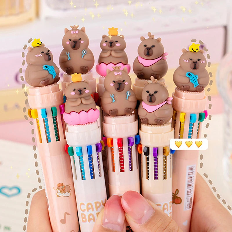 Set of colorful pens with kawaii bear-shaped caps held by a hand against a blurred background