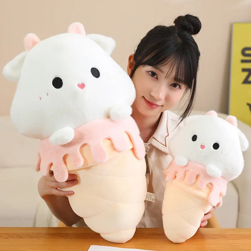 Person holding two kawaii plush cat toys with a neutral background