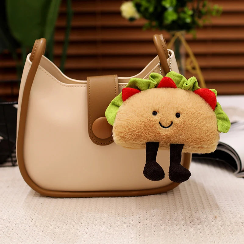 Plush taco kawaii keychain attached to a beige handbag with a blurred indoor background