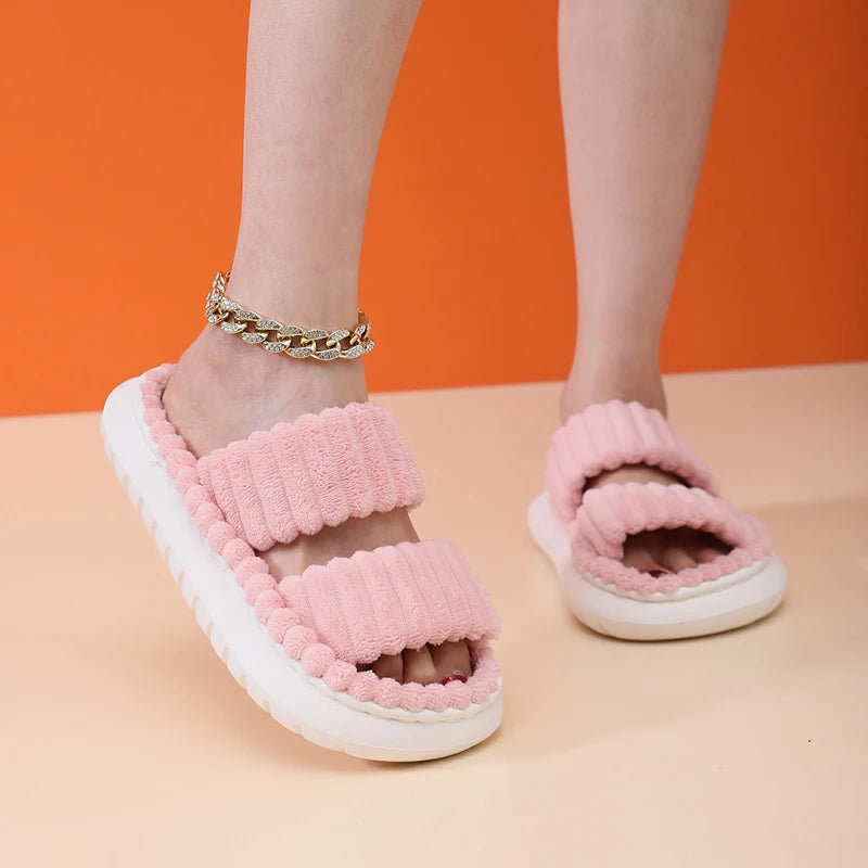 Pink fuzzy kawaii slippers worn by a person on an orange and beige background