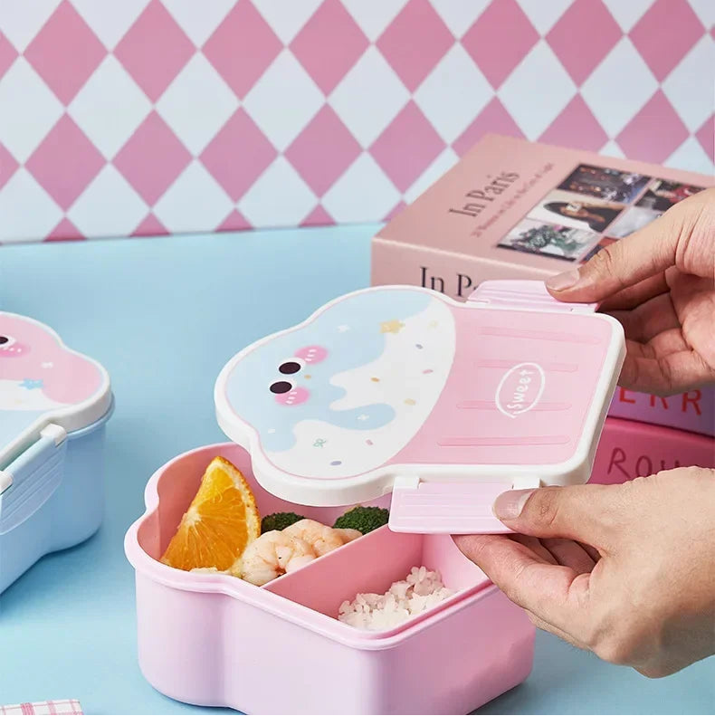 Pink kawaii bento box with compartments on a blue surface against a pink and white checkered wall.