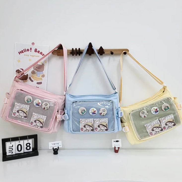 Three colorful shoulder Kawaii bags hanging on a rack with decorative items around.
