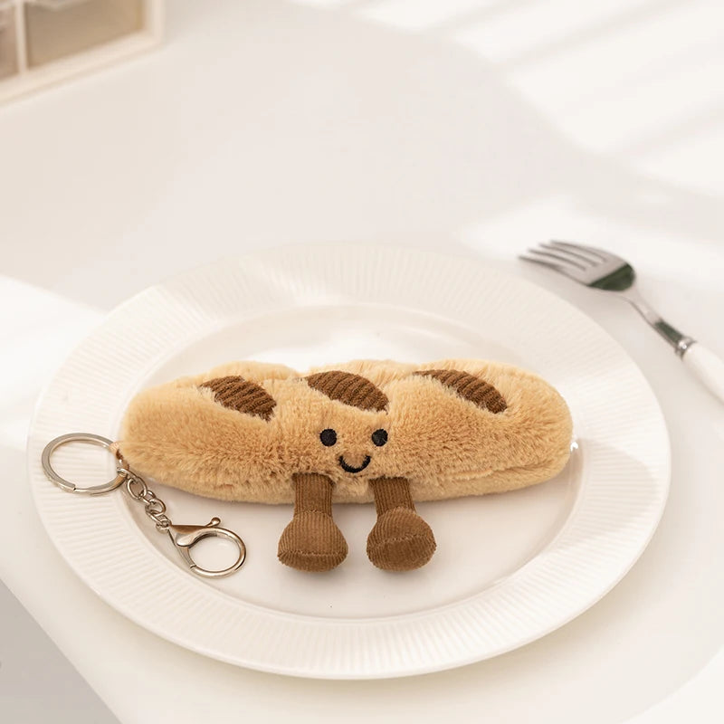 Kawaii plush bread-shaped keychain on a white plate with a fork