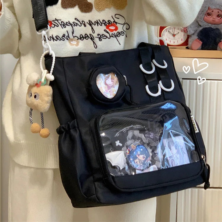 Black Kawaii backpack with decorative elements held by a person wearing a sweater with bear designs.