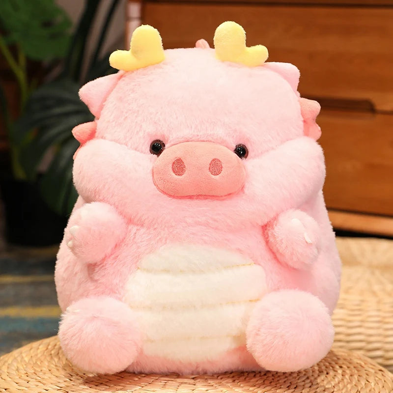 Pink kawaii plush toy with yellow horns on a woven surface