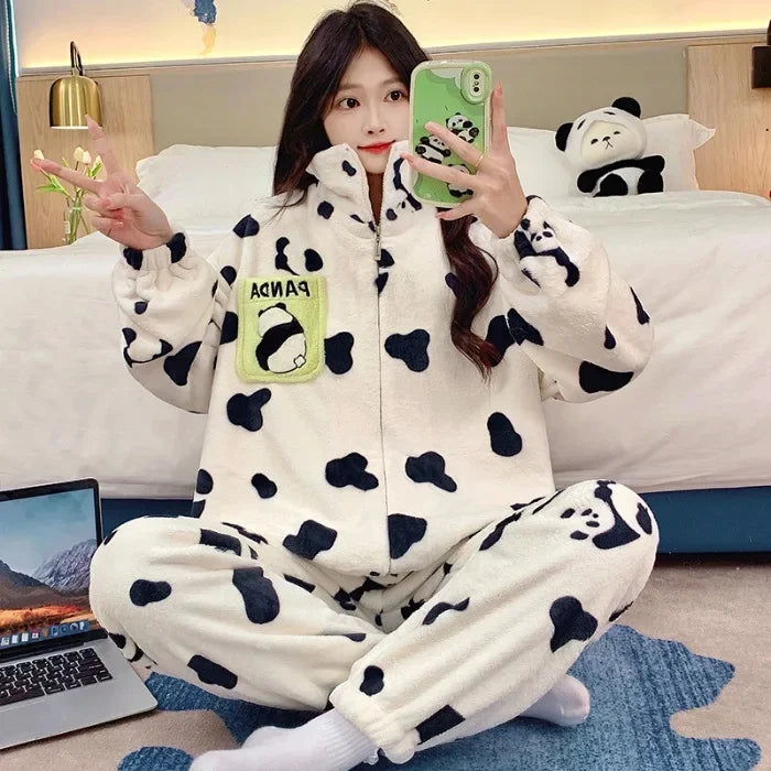 Person wearing kawaii panda-themed onesie taking a selfie in a room with a laptop and stuffed panda toy.