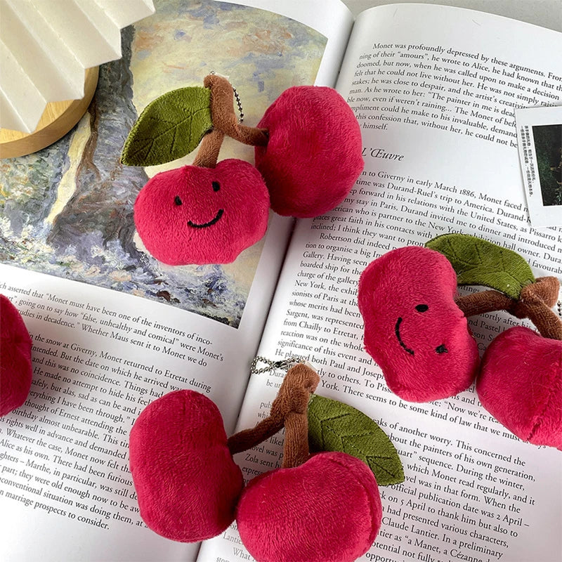 Plush kawaii red apples with smiling faces on a book