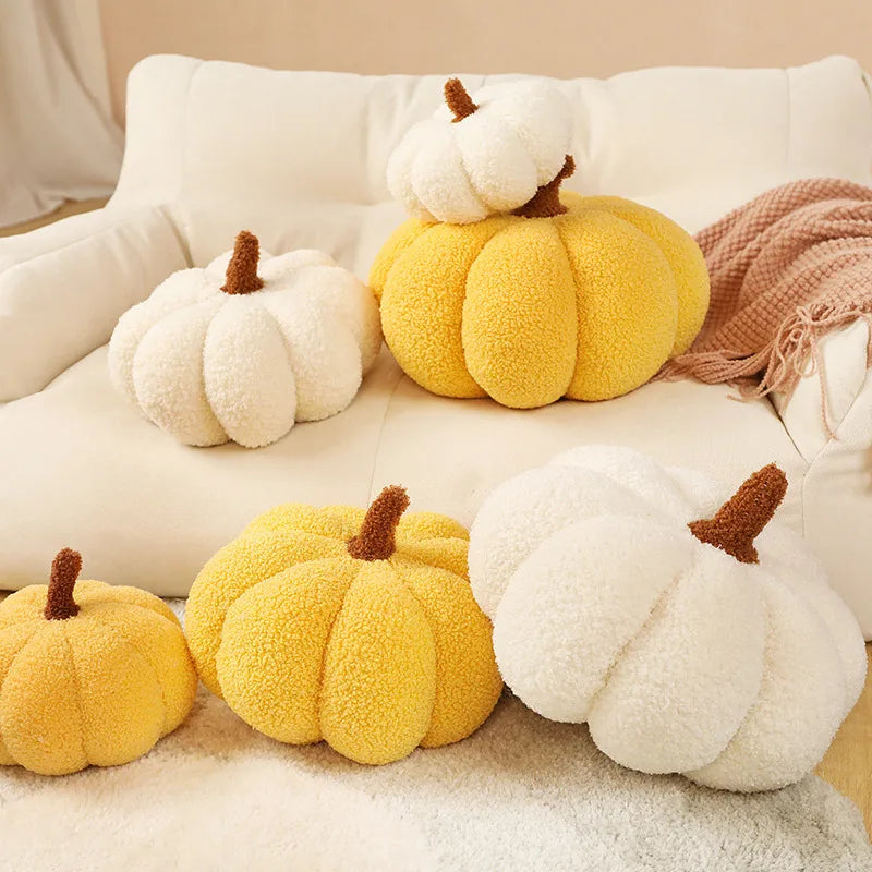 Decorative pumpkin-shaped kawaii cushions in yellow and white on a sofa.
