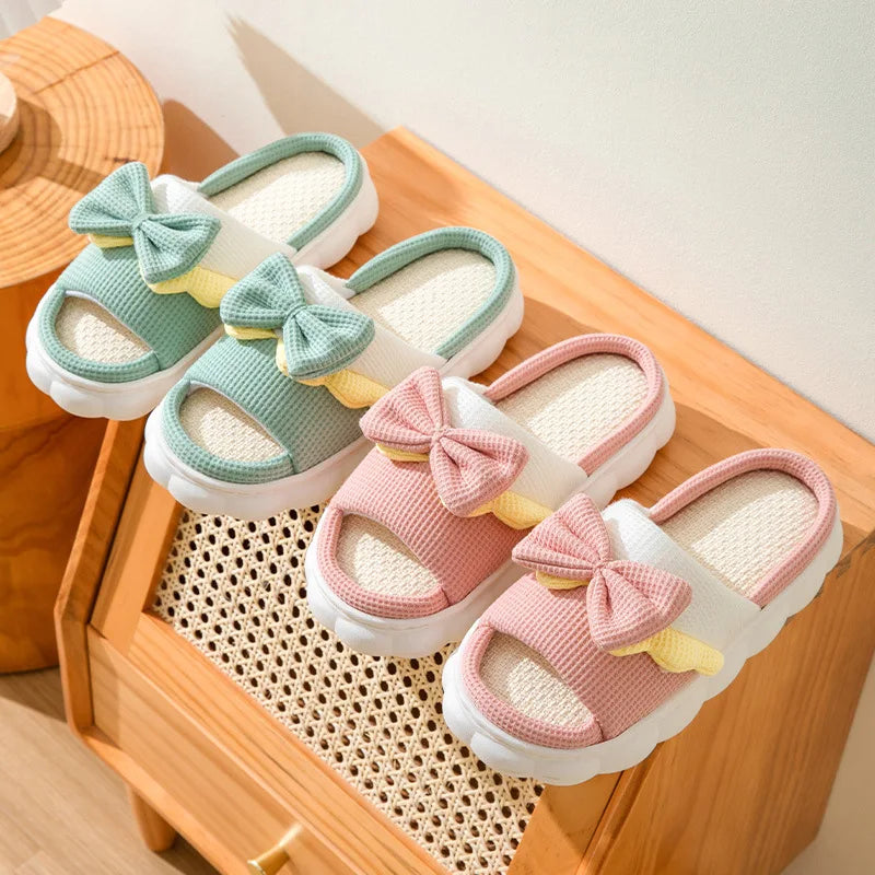 Pair of kawaii children's sandals with bows on a wooden surface
