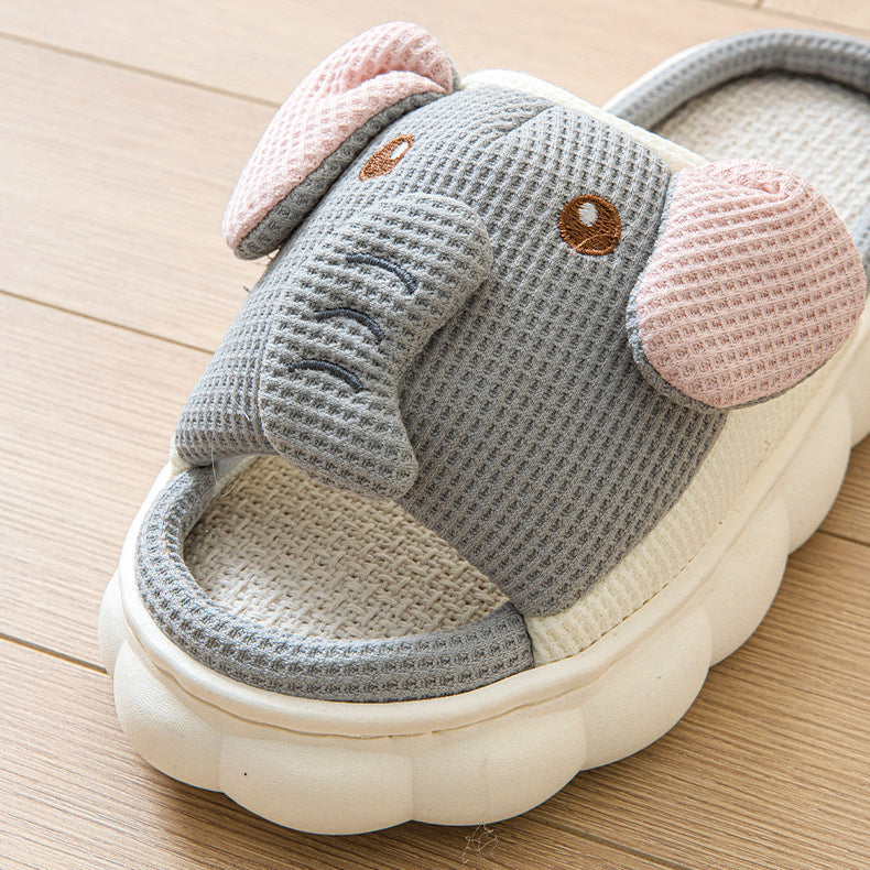 Gray kawaii elephant-shaped slippers on a wooden floor