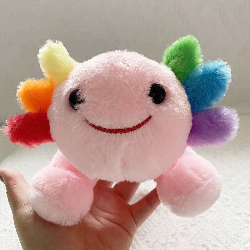 Kawaii plush toy with a smiling face and colorful pom-pom hair held by a hand against a neutral background
