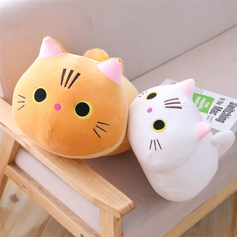 Two cartoon cat kawaii plush toys, one orange and one white, sitting on a wooden surface.