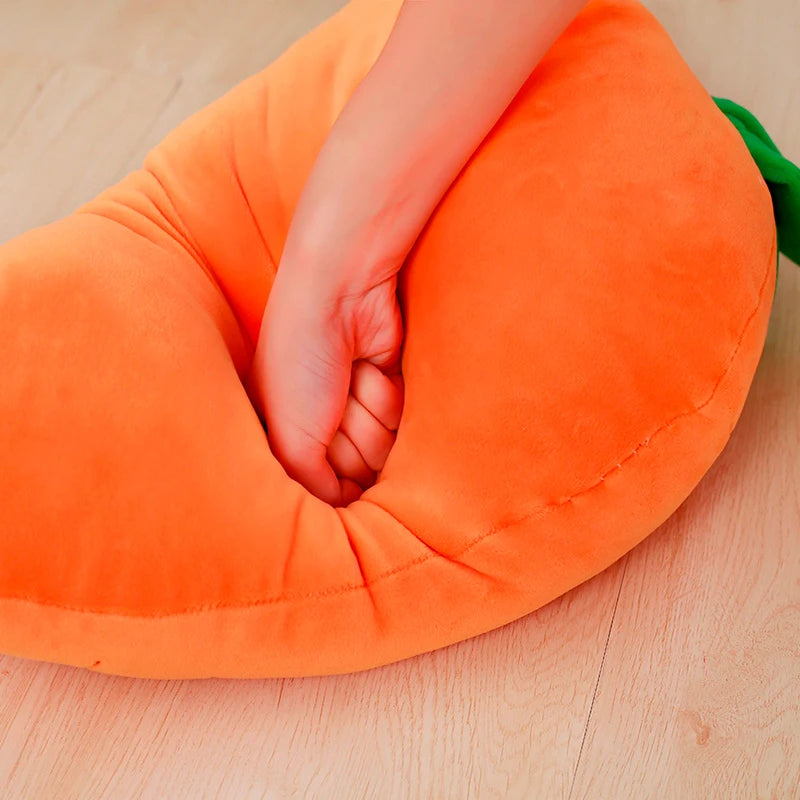 Orange kawaii carrot-shaped pillow with a hand inside on a wooden surface