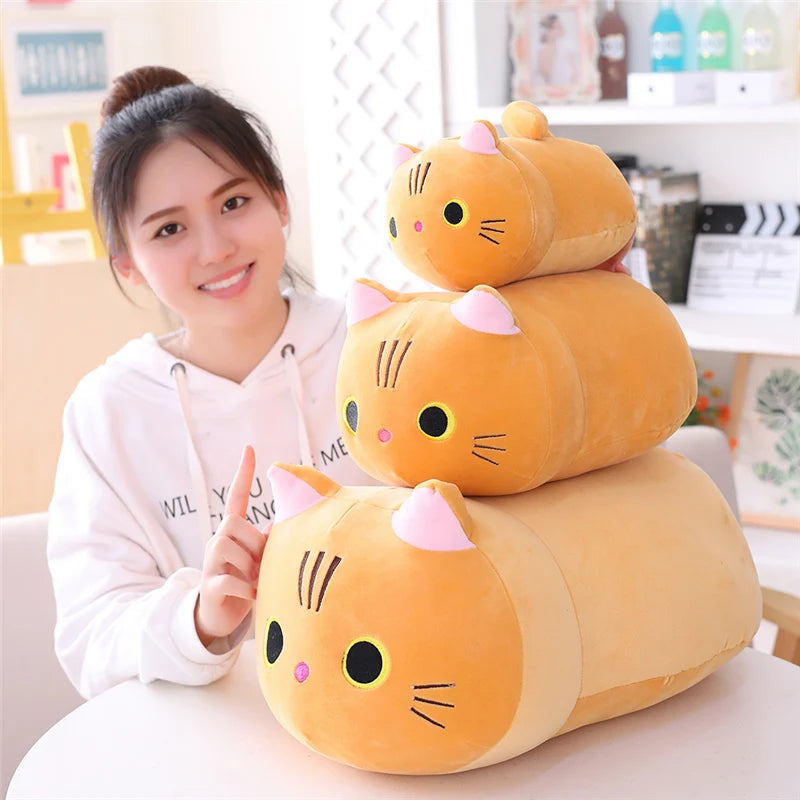 Person with a stack of kawaii cat-shaped plush toys on a table