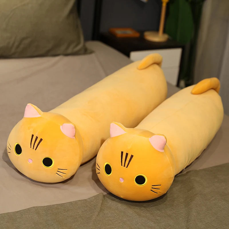 Two yellow cat-shaped kawaii cushions on a bed