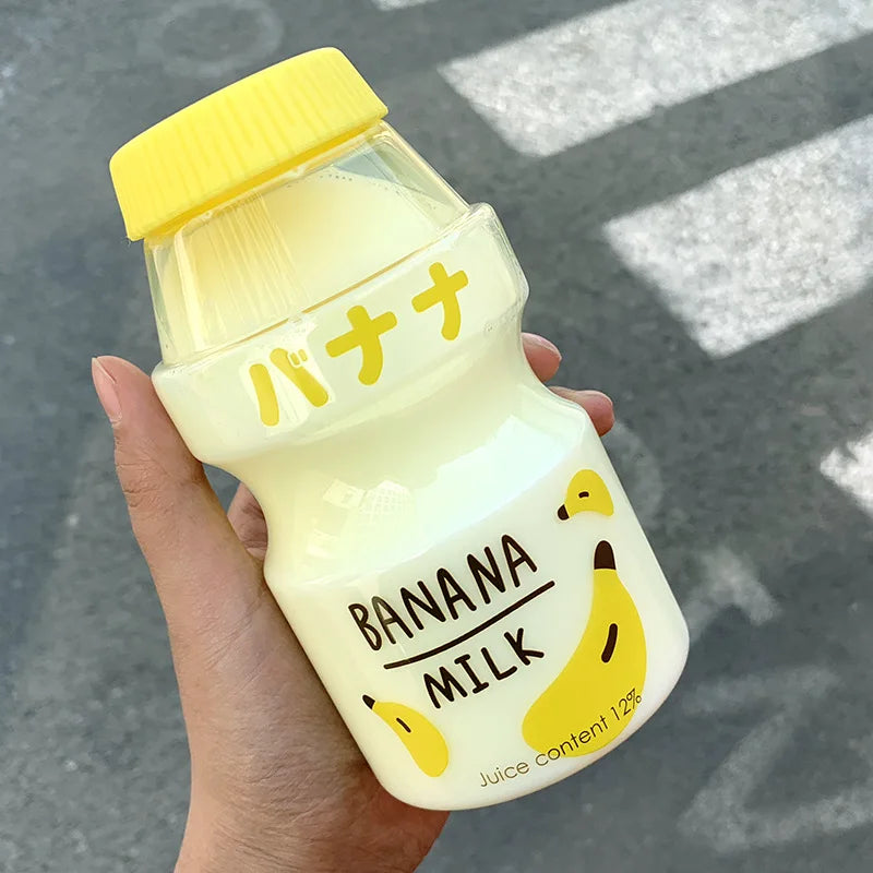 Hand holding a bottle of Kawaii banana milk with a yellow cap and Japanese text.