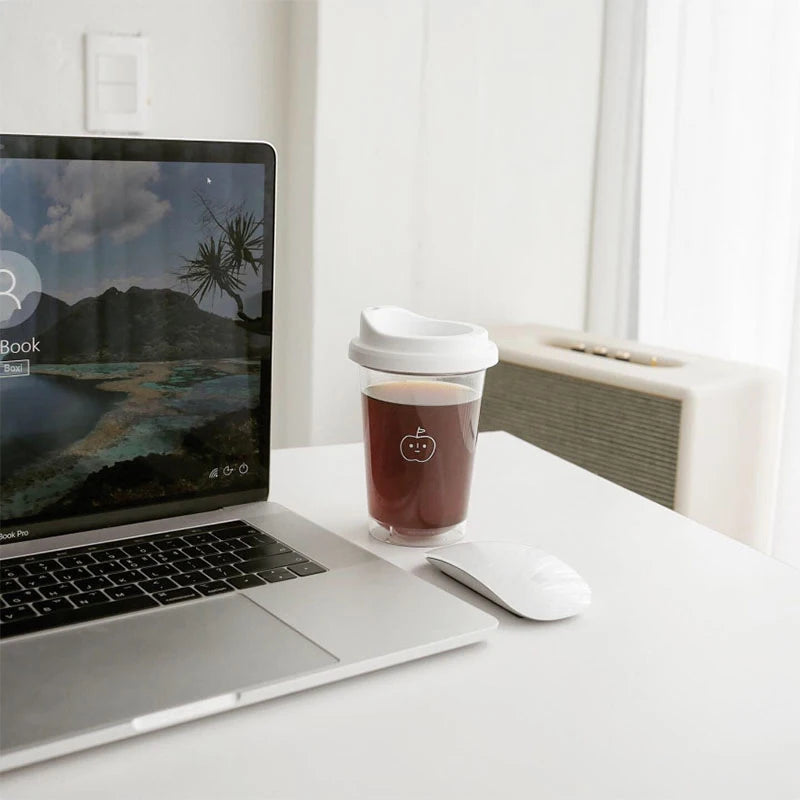 Laptop on a desk with a Kawaii coffee cup and mouse