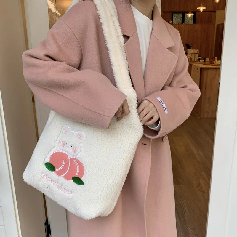 Person wearing a pink coat holding a white kawaii fluffy bag with a cartoon design.