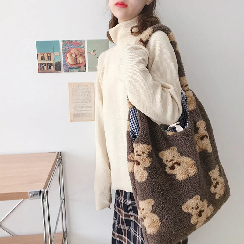 Person holding a brown tote bag with kawaii teddy bear patterns in a room setting.