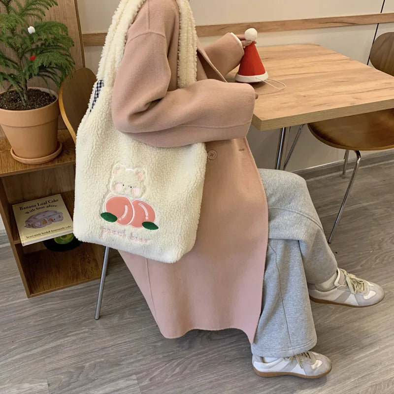 Person sitting at a table with a fluffy white kawaii bag featuring a cartoon design.
