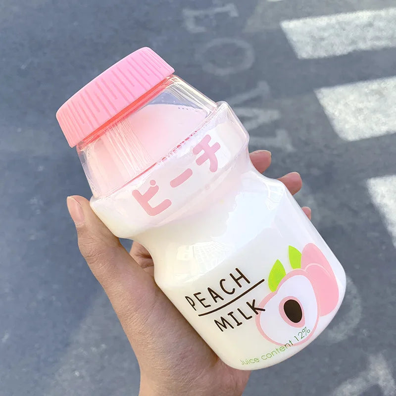 Hand holding a small Kawaii bottle labeled 'Peach Milk' with a pink cap.
