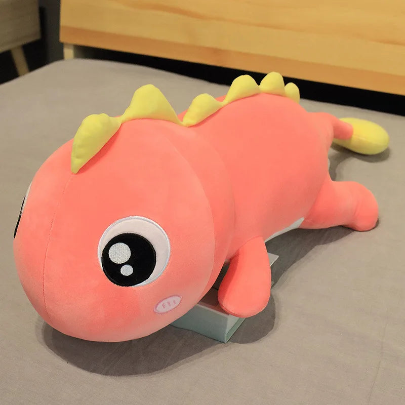 Pink kawaii plush toy with yellow spikes on a gray surface