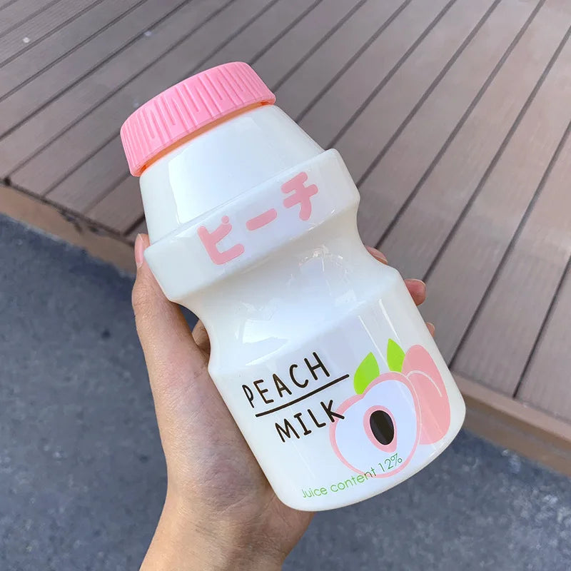 Hand holding a Kawaii bottle of peach milk with a pink cap and Japanese text.