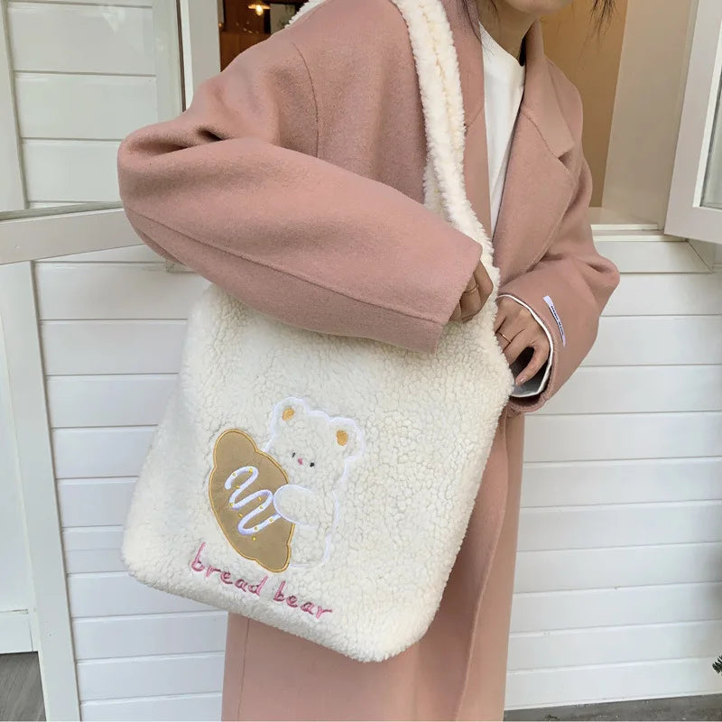 Person wearing a pink coat holding a fluffy white bag with a kawaii bear design.