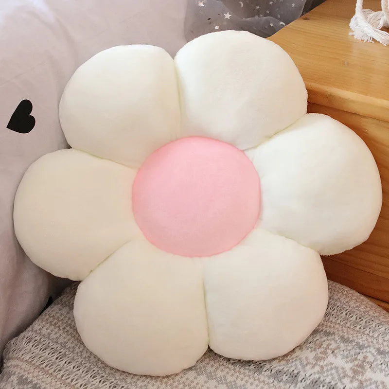 Flower-shaped Kawaii cushion with a pink center on a soft surface