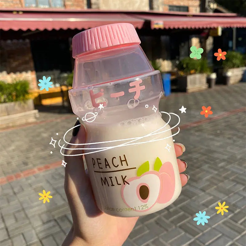 Hand holding a Kawaii bottle labeled 'Peach Milk' with decorative elements on a blurred street background