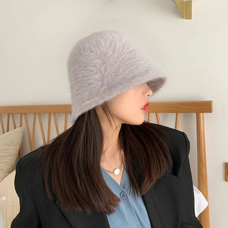 Woman wearing a gray fur Kawaii hat indoors with a neutral background