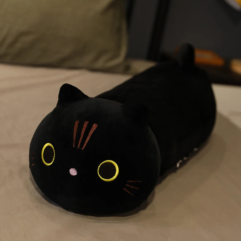 Black cat-shaped kawaii plush toy on a bed