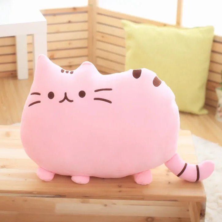 Pink cat-shaped plush kawaii toy on a wooden surface with a blurred background