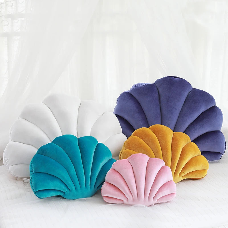 Colorful shell-shaped kawaii cushions on a white background