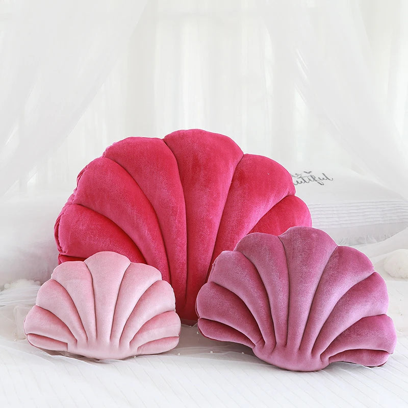 Pink shell-shaped kawaii cushions on a white background
