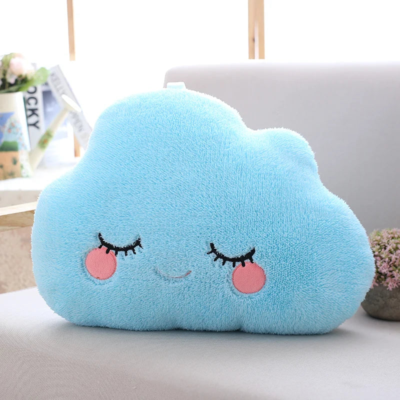 Cute blue cloud-shaped kawaii pillow with a smiling face on a light-colored surface.