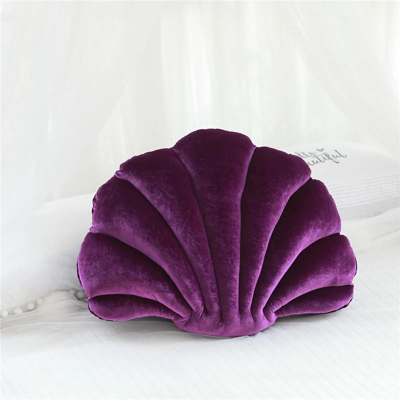 Purple shell-shaped kawaii pillow on a white surface