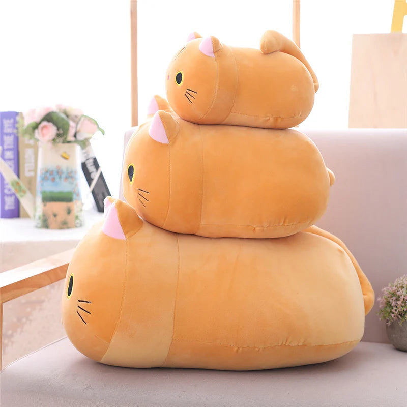 Stack of three kawaii cartoon cat-shaped cushions on a sofa