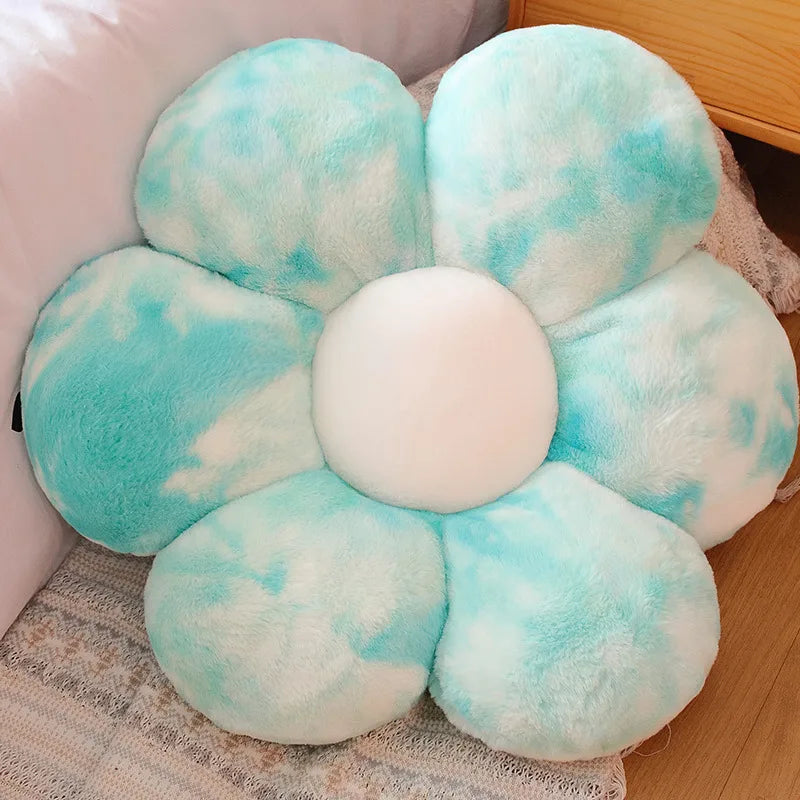 Kawaii flower-shaped pillow with blue and white petals on a wooden floor.