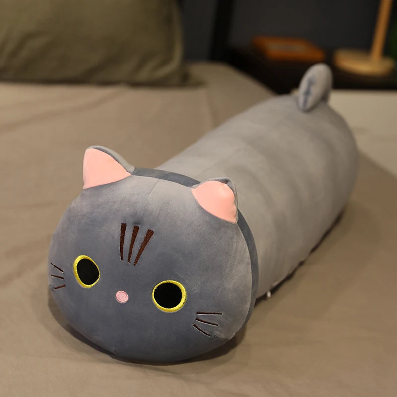 Gray cat-shaped kawaii pillow on a bed
