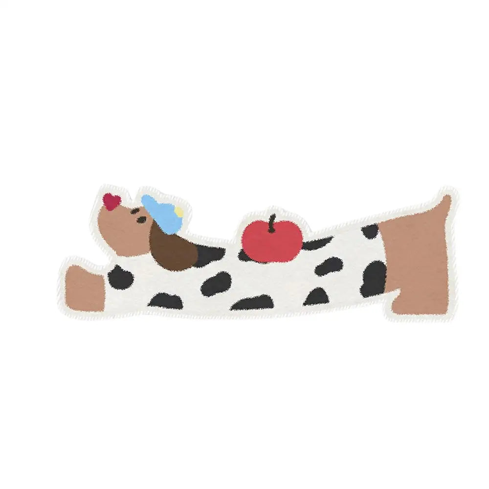Kawaii dog toy shaped like a bone with a cow print, red apple, and brown cow head on a white background