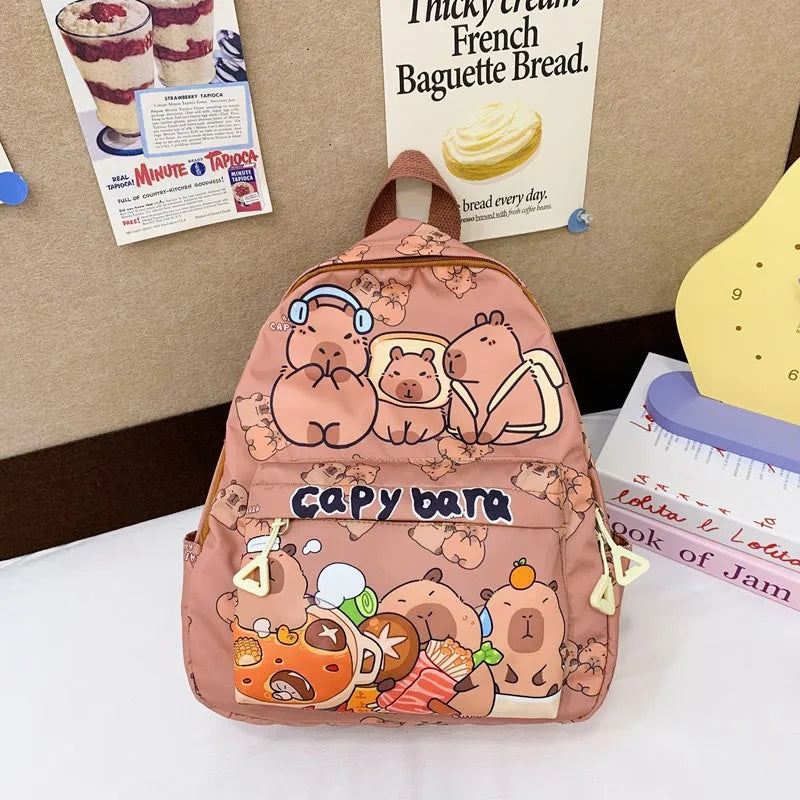 Pink backpack with Kawaii cartoon designs on a surface with posters in the background