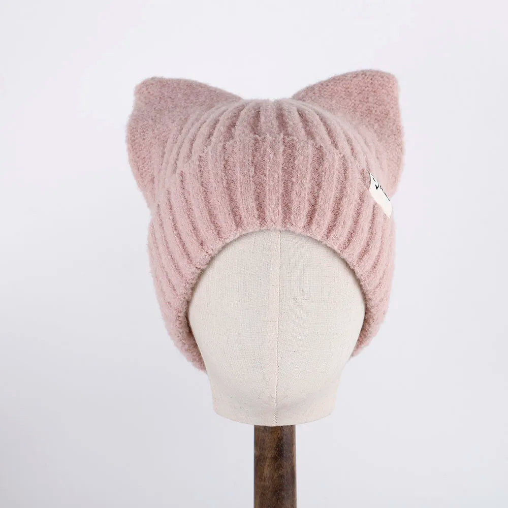 Pink knitted cat ear Kawaii hat on a mannequin head against a white background