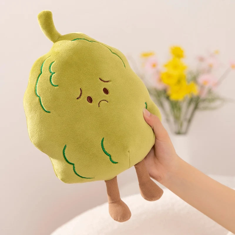 Plush kawaii toy shaped like a pear with a sad expression held by a hand against a light background.