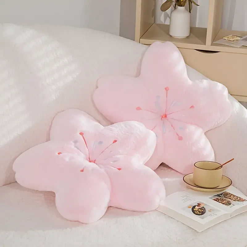 Pink flower-shaped Kawaii cushions on a white sofa with a cup and saucer.