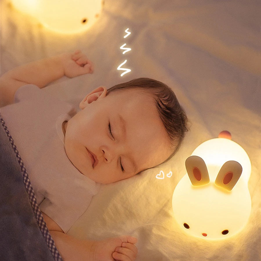 Baby sleeping next to a glowing rabbit-shaped kawaii night light