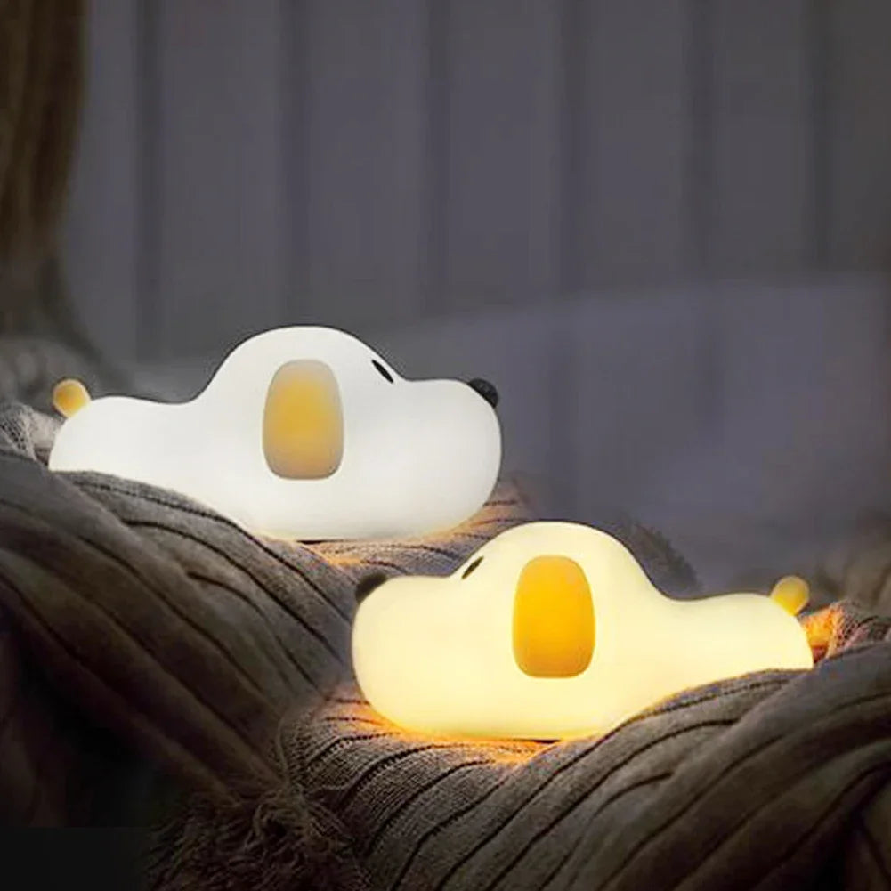 Two cartoon duck kawaii night lights on a soft surface with a blurred background